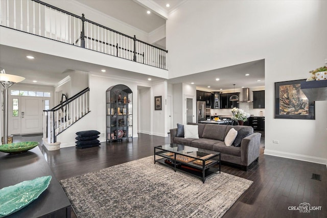 3578 Doral Dr, Elgin, IL 60124 - living area with ornamental molding, dark wood finished floors, a high ceiling, stairs, and arched walkways