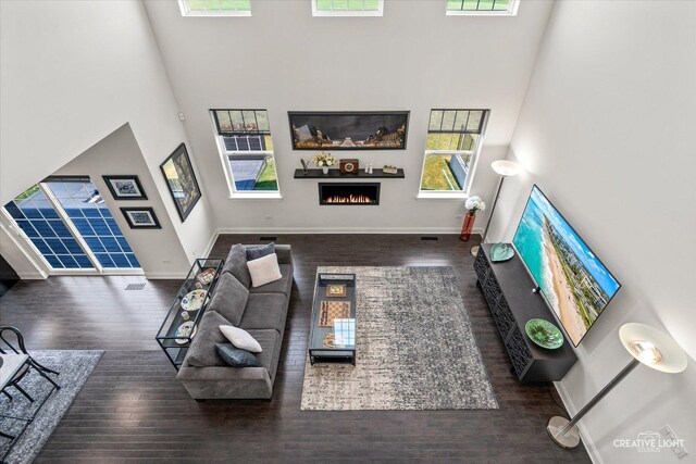 3578 Doral Dr, Elgin, IL 60124 - living area with a lit fireplace, wood finished floors, and a towering ceiling
