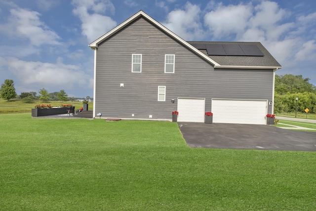 3578 Doral Dr, Elgin, IL 60124 - view of property exterior featuring a garage, roof mounted solar panels, asphalt driveway, and a lawn