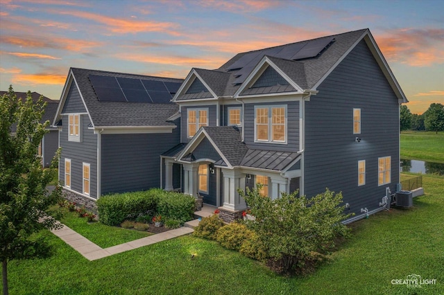 3578 Doral Dr, Elgin, IL 60124 - view of front of property featuring a standing seam roof, a lawn, solar panels, and a metal roof