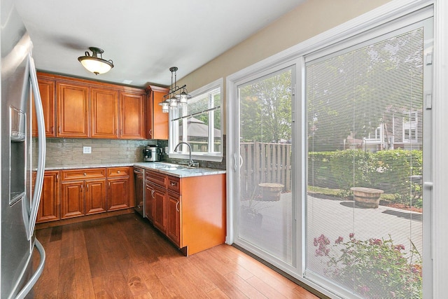 2165 Greystone Pl, Hoffman Estates, IL 60169 - kitchen featuring appliances with stainless steel finishes, dark wood-style floors, tasteful backsplash, light stone countertops, and decorative light fixtures
