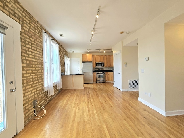 2537.5 Prairie Ave Unit 3N, Evanston, IL 60201 - unfurnished living room with light wood-style floors, brick wall, and track lighting