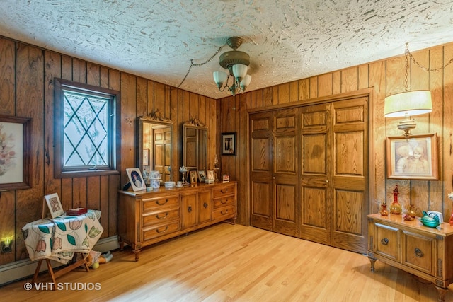 14119 W Maple Rd, Mokena, IL 60448 - bedroom with light wood-style flooring, wooden walls, and a textured ceiling