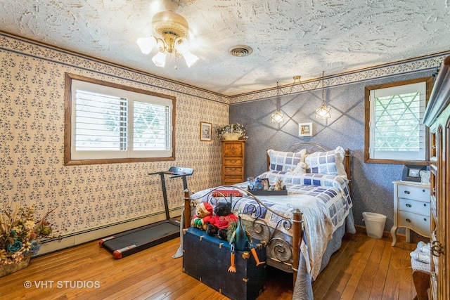 14119 W Maple Rd, Mokena, IL 60448 - bedroom with a baseboard radiator, wood-type flooring, wallpapered walls, and ornamental molding