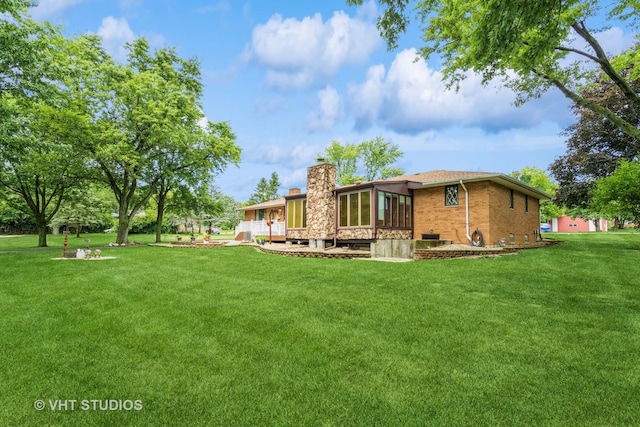 14119 W Maple Rd, Mokena, IL 60448 - back of house featuring a chimney, a yard, brick siding, and a sunroom