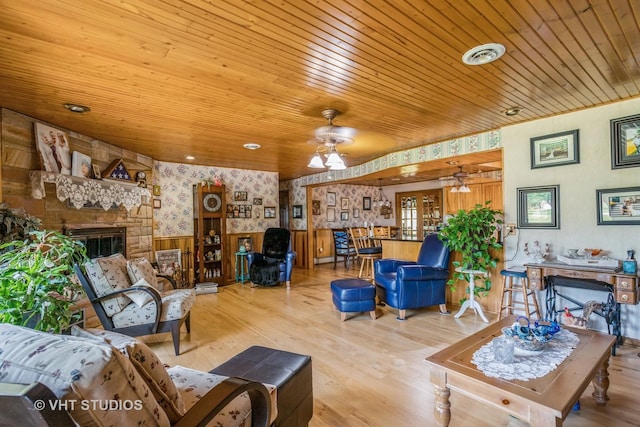 14119 W Maple Rd, Mokena, IL 60448 - living area with wallpapered walls, wainscoting, ceiling fan, a stone fireplace, and wooden ceiling