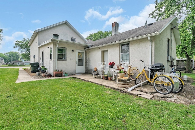 107 N Elm St, Gardner, IL 60424 - back of house featuring a chimney, stucco siding, a yard, and roof with shingles