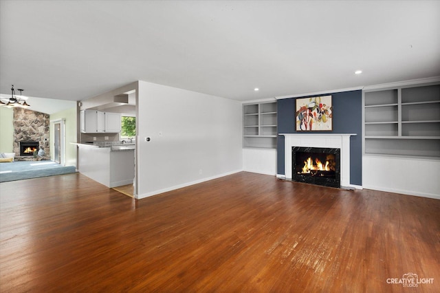 306 Hillside Pl, North Aurora, IL 60542 - unfurnished living room featuring a high end fireplace, wood finished floors, built in shelves, and recessed lighting