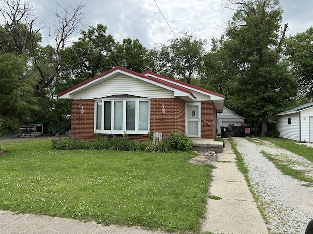 319 N Third St, Fisher, IL 61843 - bungalow featuring brick siding, a front lawn, and driveway