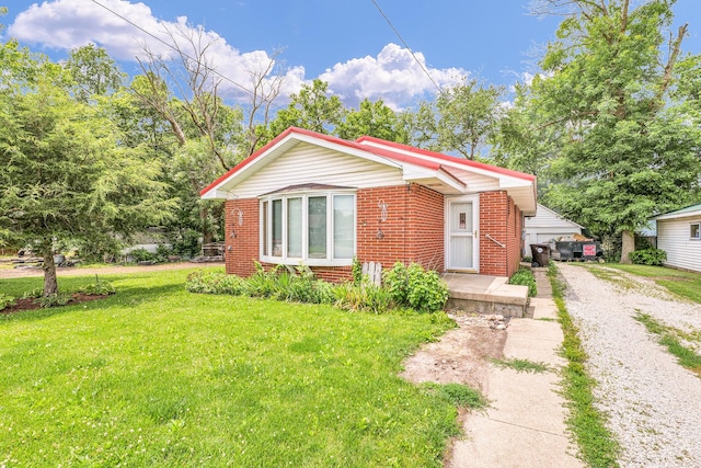 319 N Third St, Fisher, IL 61843 - bungalow-style house with brick siding, driveway, and a front yard