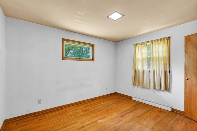 319 N Third St, Fisher, IL 61843 - empty room with a baseboard heating unit and hardwood / wood-style flooring