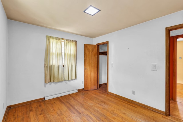 319 N Third St, Fisher, IL 61843 - unfurnished bedroom with a baseboard heating unit and wood finished floors