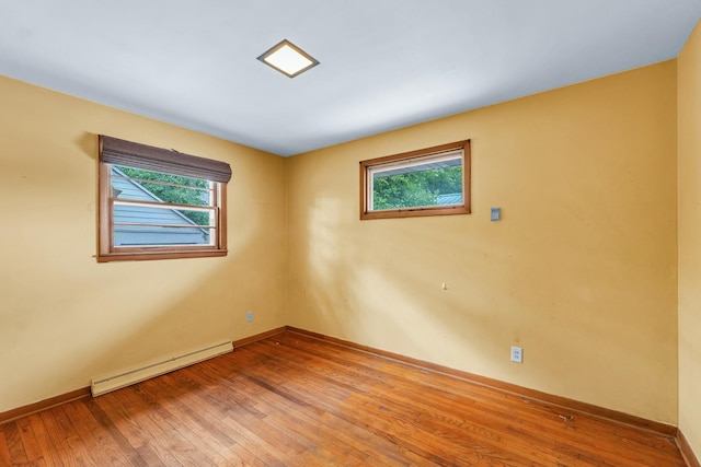 319 N Third St, Fisher, IL 61843 - empty room with a baseboard heating unit and light wood finished floors