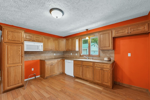 319 N Third St, Fisher, IL 61843 - kitchen with white appliances, light wood-style floors, brown cabinets, backsplash, and a textured ceiling