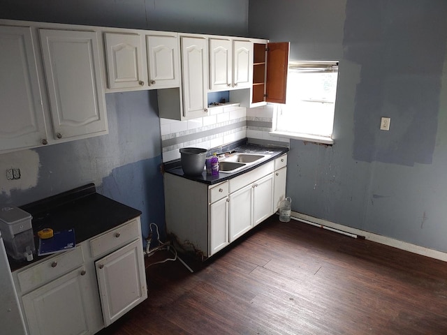 kitchen with white cabinets, dark wood-style floors, dark countertops, and decorative backsplash