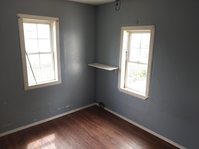 unfurnished room featuring plenty of natural light and wood finished floors