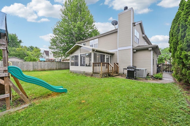 1643 Warrington Ln, Crystal Lake, IL 60014 - back of property with a sunroom, a playground, a fenced backyard, a chimney, and a deck