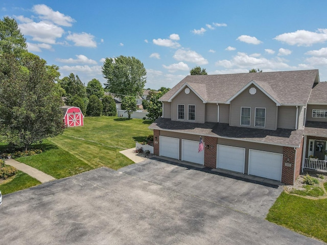 236 Marquette Pl S, Manteno, IL 60950 - view of front of house featuring asphalt driveway, an attached garage, brick siding, a front yard, and roof with shingles