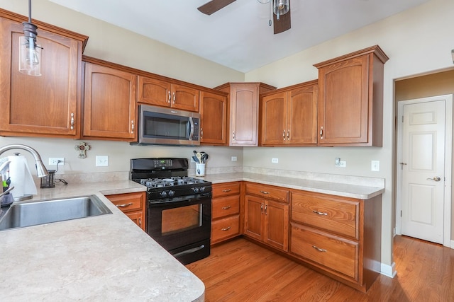 236 Marquette Pl S, Manteno, IL 60950 - kitchen featuring black gas range, stainless steel microwave, light wood-type flooring, light countertops, and a ceiling fan