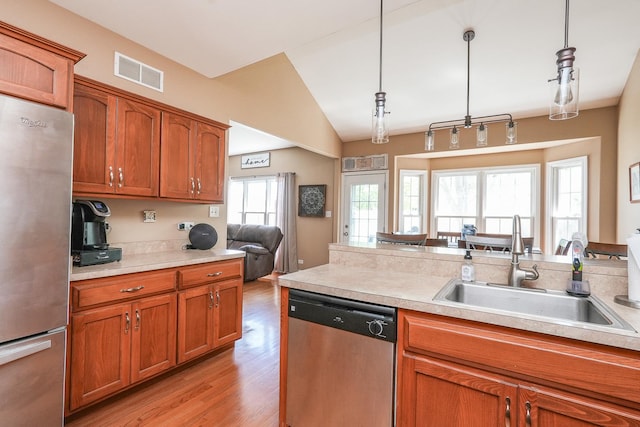 236 Marquette Pl S, Manteno, IL 60950 - kitchen featuring stainless steel appliances, brown cabinetry, light countertops, light wood-style floors, and pendant lighting