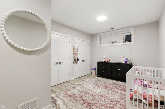 1437 W Grand Ave Unit 1S, Chicago, IL 60642 - bedroom featuring multiple closets, wood finished floors, and a nursery area