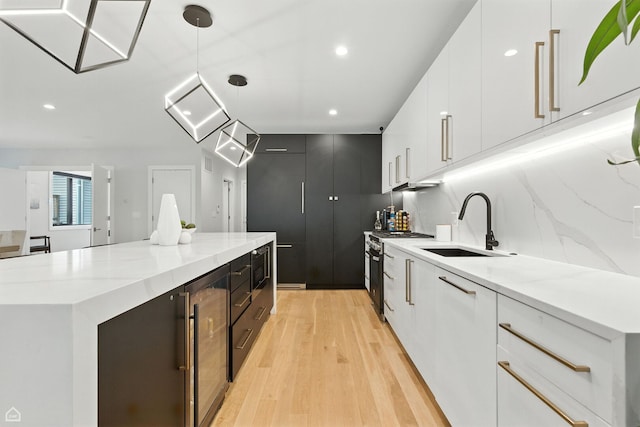 1437 W Grand Ave Unit 1S, Chicago, IL 60642 - kitchen with modern cabinets, a center island, light wood-type flooring, high end stove, and white cabinetry