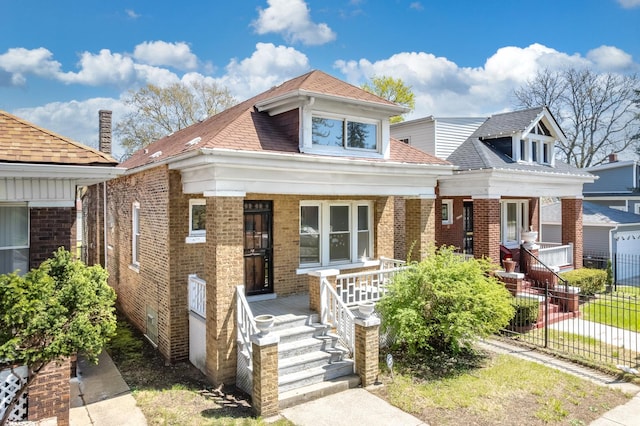 7647 S Calumet Ave, Chicago, IL 60619 - view of front of property featuring covered porch, brick siding, and roof with shingles