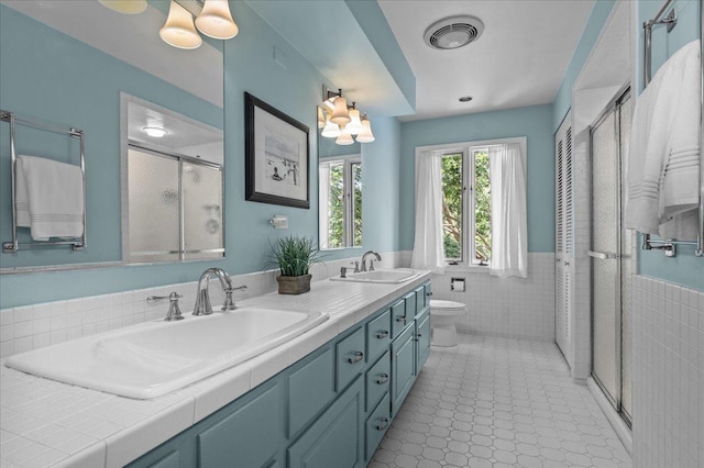 67 Brandon Rd, Northfield, IL 60093 - full bathroom with tile walls, a shower stall, wainscoting, double vanity, and tile patterned floors