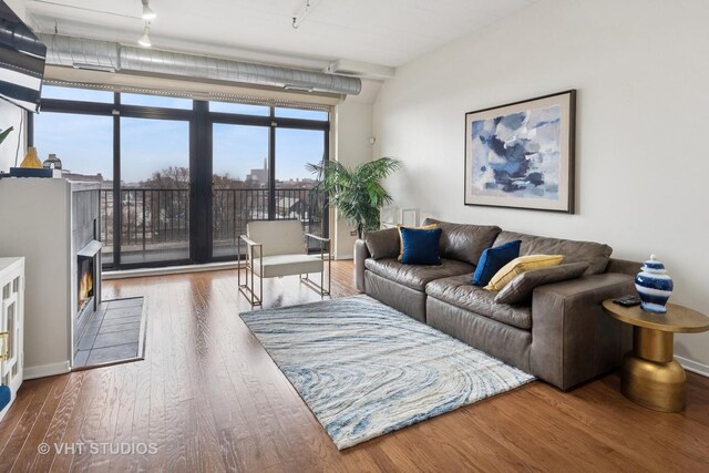 1524 S Sangamon St Unit 413-S, Chicago, IL 60608 - living room featuring wood finished floors, a lit fireplace, track lighting, and a wall of windows