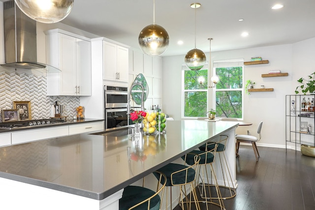 3551 Kemper Dr, Woodridge, IL 60517 - kitchen with wall chimney exhaust hood, dark countertops, appliances with stainless steel finishes, backsplash, and white cabinets