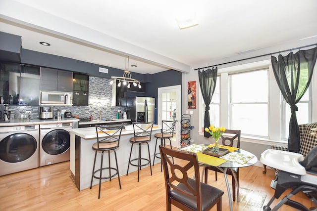 4220 S Champlain Ave Unit 2N, Chicago, IL 60653 - dining area with separate washer and dryer, light wood finished floors, and a chandelier