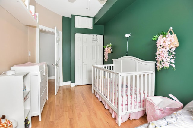 4220 S Champlain Ave Unit 2N, Chicago, IL 60653 - bedroom featuring light wood-type flooring, a closet, a nursery area, and a ceiling fan