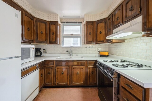 2931 N Lowell Ave, Chicago, IL 60641 - kitchen with white appliances, under cabinet range hood, backsplash, and light countertops