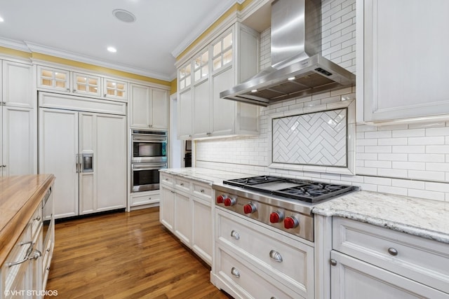 1419 Judson Ave, Evanston, IL 60201 - kitchen featuring wall chimney range hood, stainless steel appliances, crown molding, decorative backsplash, and wood finished floors