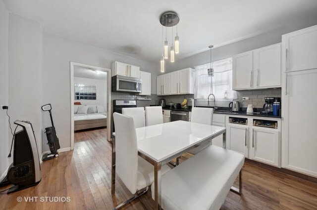 5443 S Long Ave, Chicago, IL 60638 - kitchen featuring appliances with stainless steel finishes, tasteful backsplash, white cabinetry, and wood finished floors