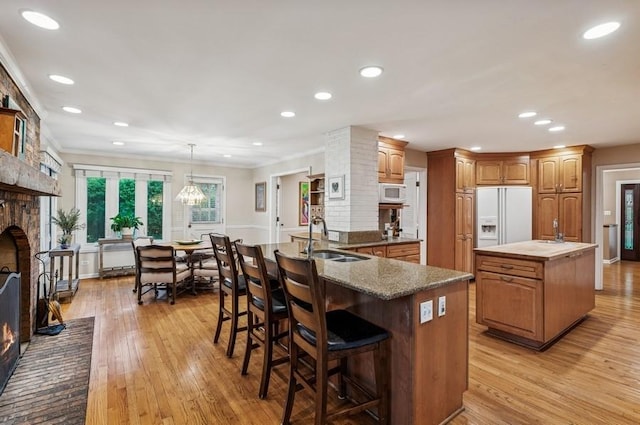 2810 Beckwith Ct, Northbrook, IL 60062 - kitchen with a kitchen island, white appliances, a brick fireplace, light wood-style floors, and recessed lighting