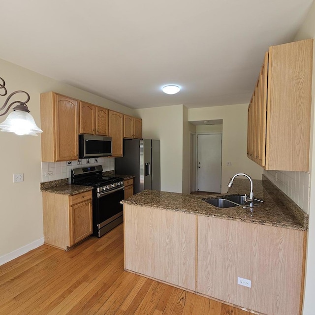 4029 Boulder Ct, Aurora, IL 60504 - kitchen featuring stainless steel appliances, a peninsula, decorative backsplash, light wood-style floors, and dark stone counters