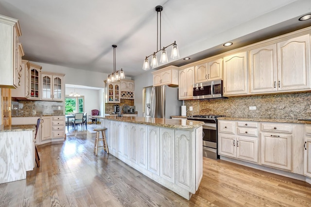 1383 Gordon Ln, Lemont, IL 60439 - kitchen with appliances with stainless steel finishes, decorative backsplash, glass insert cabinets, an island with sink, and recessed lighting
