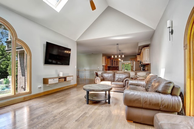 1383 Gordon Ln, Lemont, IL 60439 - living area with light wood finished floors, high vaulted ceiling, a skylight, and a ceiling fan