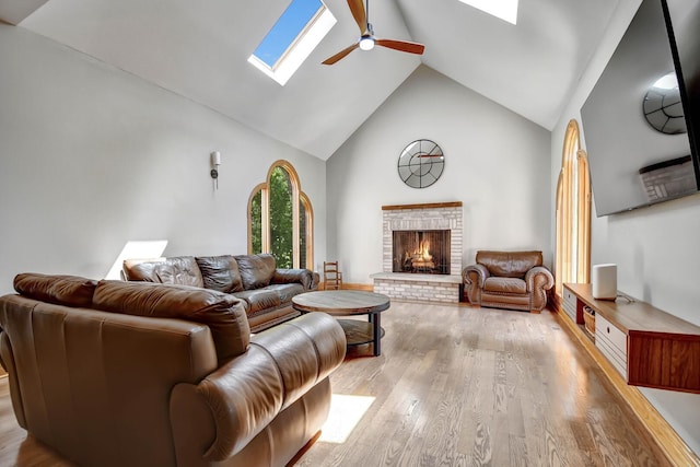 1383 Gordon Ln, Lemont, IL 60439 - living area featuring a skylight, high vaulted ceiling, ceiling fan, light wood-style floors, and a brick fireplace