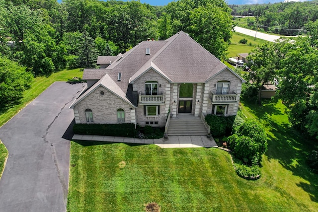 1383 Gordon Ln, Lemont, IL 60439 - view of front of house featuring roof with shingles, stone siding, a front yard, and a balcony