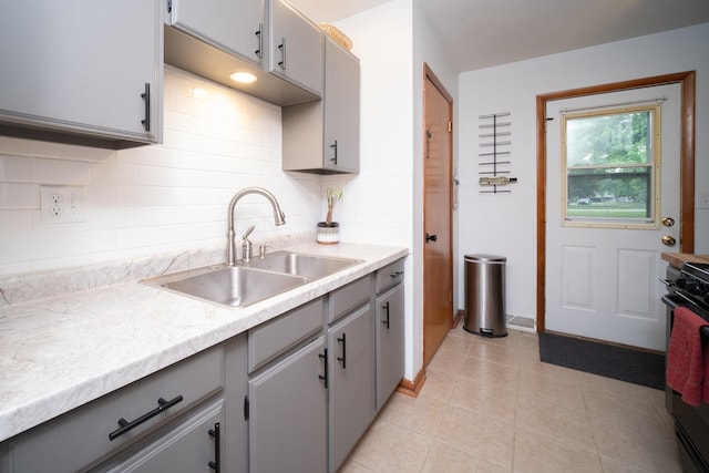 14194 Kennedy Dr, South Beloit, IL 61080 - kitchen featuring gray cabinets, range, light countertops, light tile patterned flooring, and tasteful backsplash