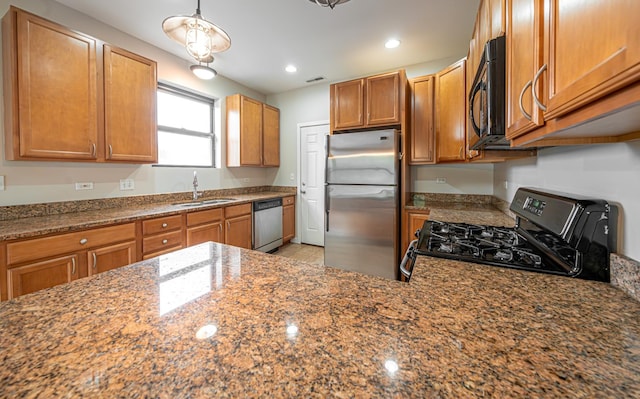 6829 N Lakewood Ave Unit 3, Chicago, IL 60626 - kitchen with stainless steel appliances, dark stone counters, recessed lighting, brown cabinetry, and hanging light fixtures