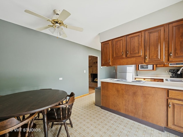 3004 Blarneystone Ln, Cary, IL 60013 - kitchen with white appliances, light countertops, a ceiling fan, brown cabinetry, and light flooring