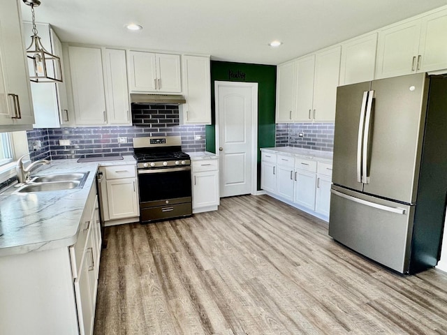 1389 Clifton Ave, Beecher, IL 60401 - kitchen featuring appliances with stainless steel finishes, under cabinet range hood, tasteful backsplash, light wood-style flooring, and white cabinetry