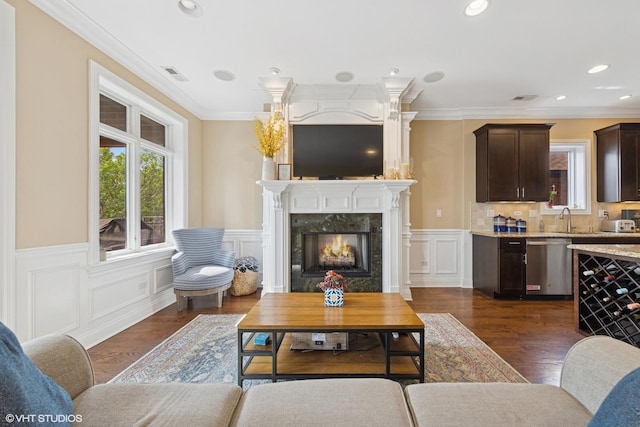 3252 N California Ave Unit 2, Chicago, IL 60618 - living room featuring plenty of natural light, dark wood-type flooring, a high end fireplace, a wainscoted wall, and crown molding