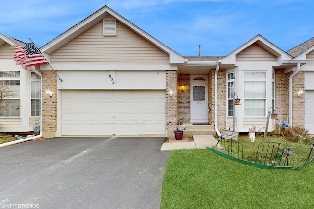 832 Veridian Way Unit 832, Cary, IL 60013 - view of front facade with brick siding, asphalt driveway, a garage, a front yard, and roof with shingles