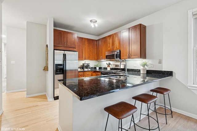 1048 W Lill Ave Unit 2, Chicago, IL 60614 - kitchen featuring stainless steel appliances, a peninsula, light wood-type flooring, and brown cabinetry