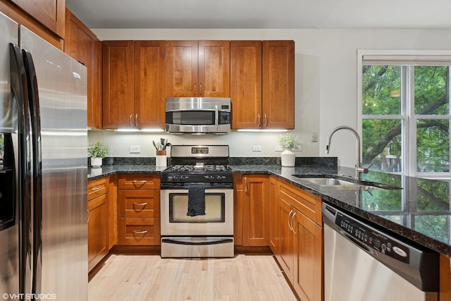 1048 W Lill Ave Unit 2, Chicago, IL 60614 - kitchen with stainless steel appliances, dark stone counters, light wood finished floors, and brown cabinetry