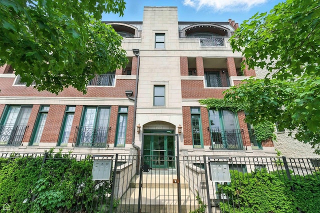 2736 N Wolcott Ave Unit 101, Chicago, IL 60614 - view of front of property featuring brick siding, a fenced front yard, and a gate